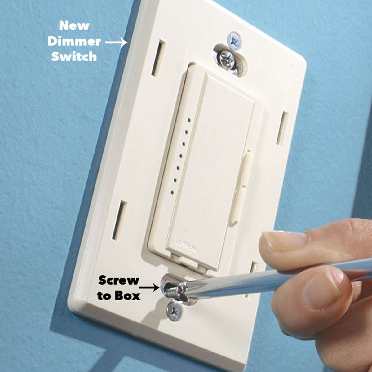 A hand tightens a screw on a new dimmer switch mounted on a light switch plate, positioned against a blue wall.