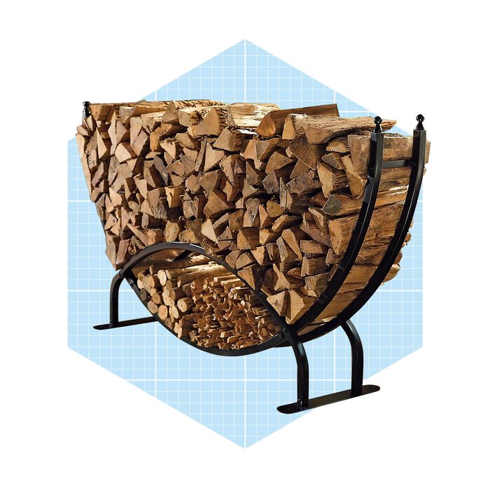 A curved metal rack holds stacked firewood, displaying wood logs in an organized manner on a light blue grid background.