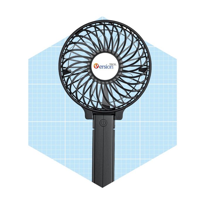 A black handheld fan circulates air, featuring a circular design with a central button and logo. It is set against a light blue grid background.