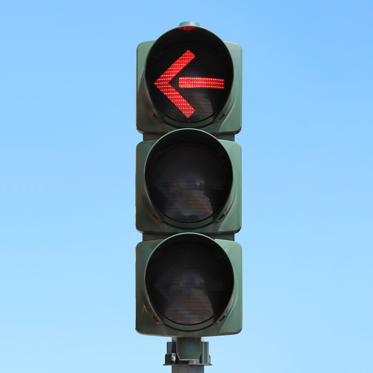 Traffic light isolated in the sky with Red arrow light on.