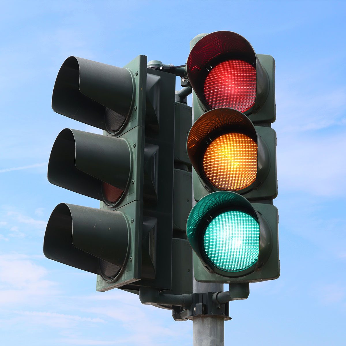 Traffic light isolated in the sky with all the lights on.